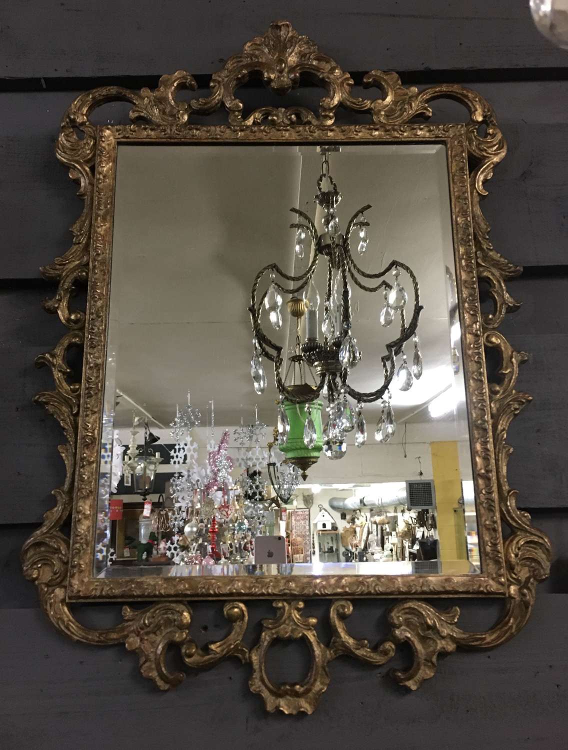 Bevelled glass mirror in an ornate gilded and aged frame